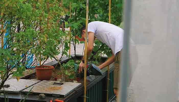 Photo d'un jardinier ajoutant du terreau dans une jardinière en milieu urbain