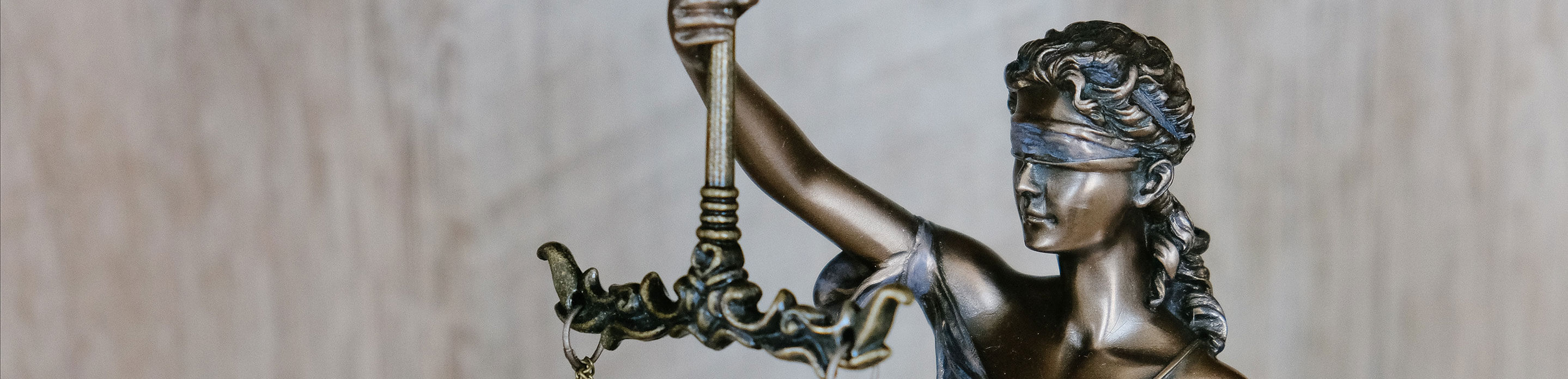 Sculpture de femme aux yeux bandés tenant une balance dans sa main, symbole de la justice.